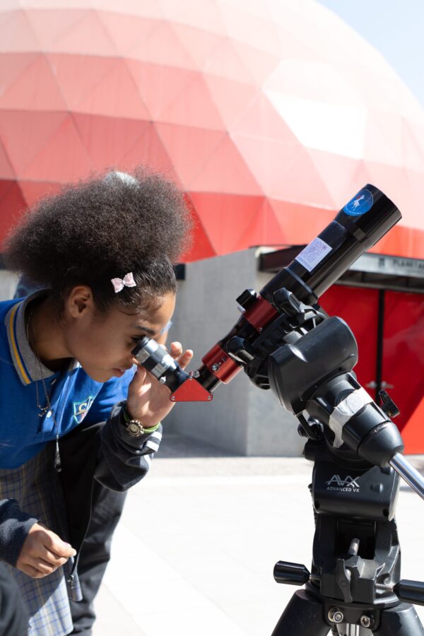 Participante observando por un telescopio durante una actividad Astro Ruta